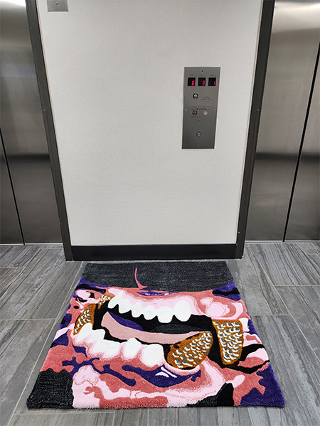 Handmade custom art rug placed in an elevator lobby