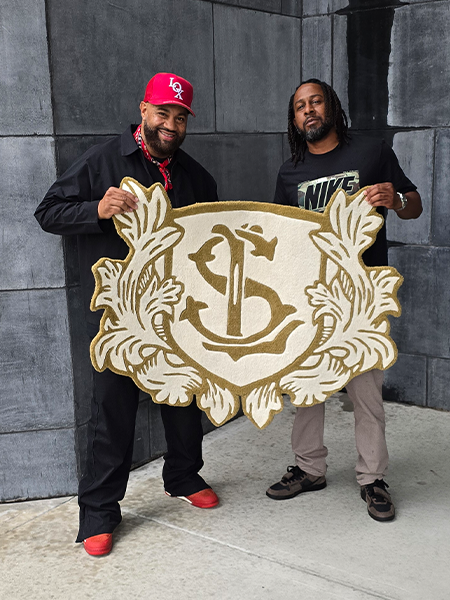 Custom crest logo rug held by two people for scale