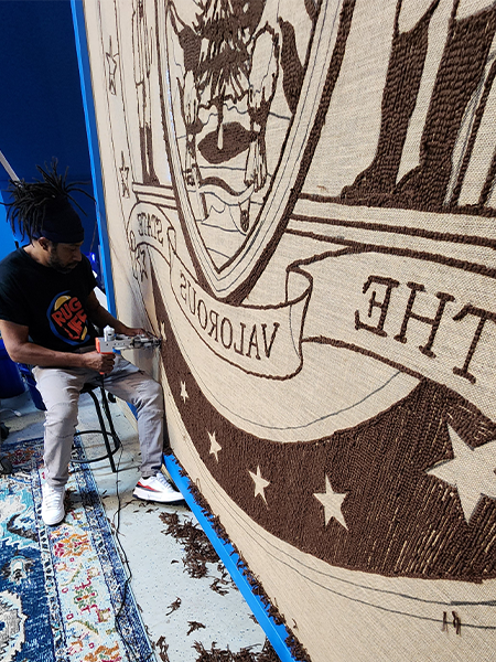 Rug maker working in the studio on a large custom rug