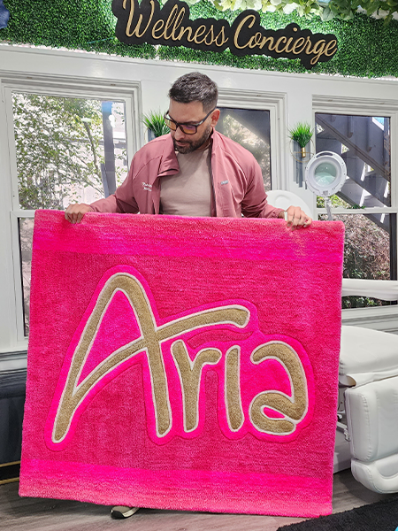 Bright pink custom name rug designed for a studio or home